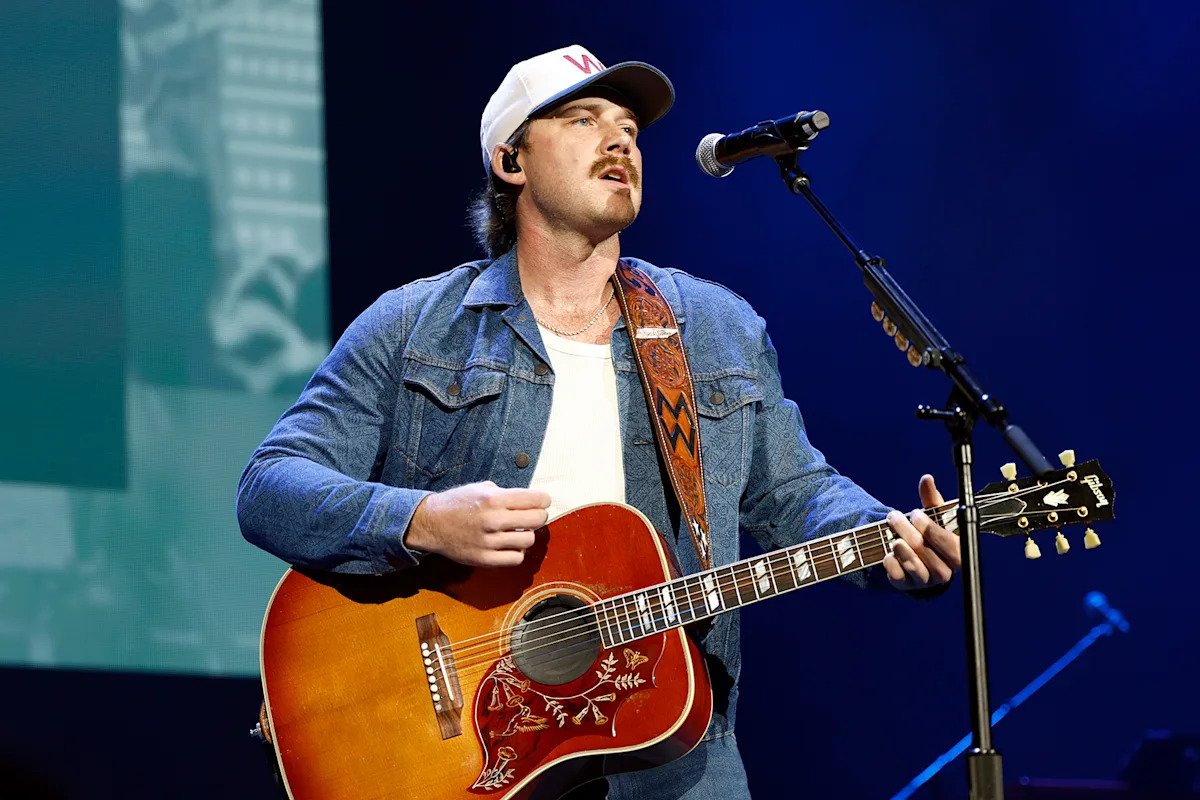 Morgan Wallen Flips Off a Charley Crockett T-Shirt Held by Gavin Adcock